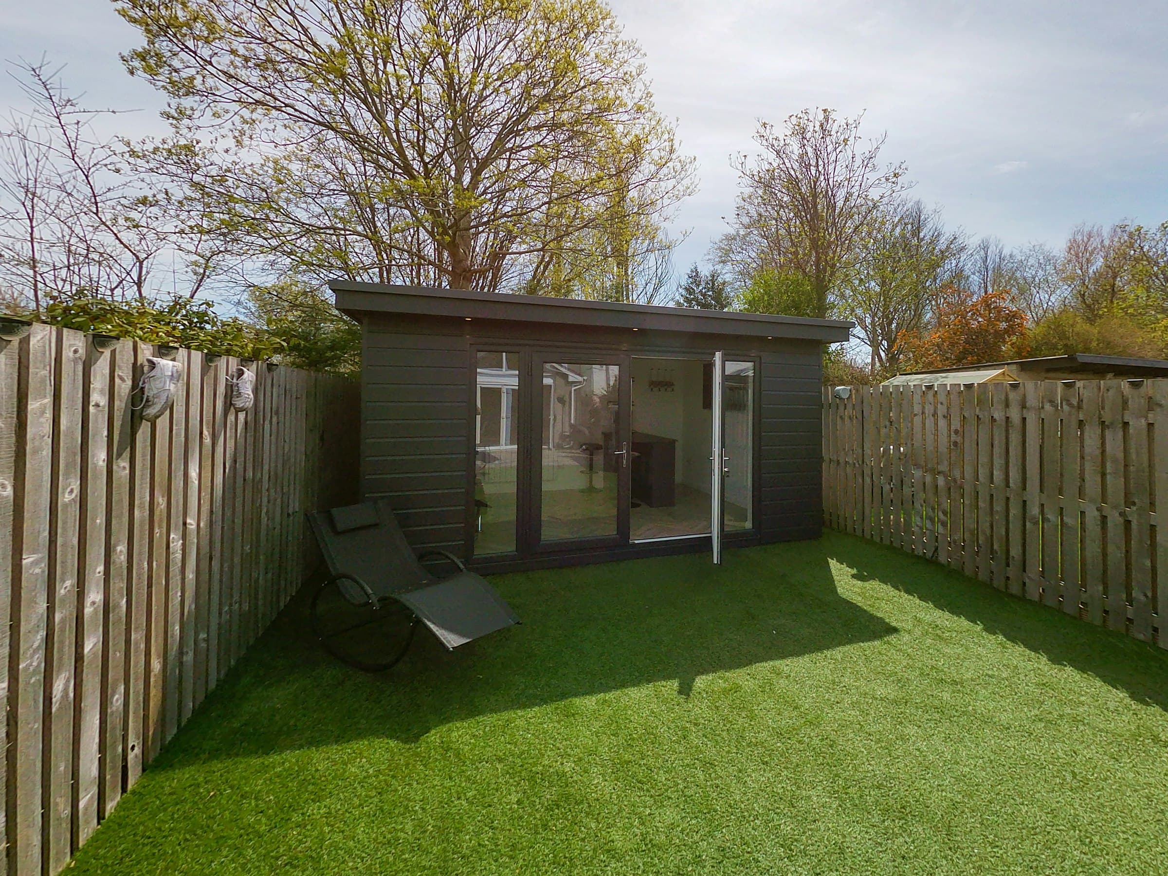 Prefab bijgebouw als tuinstudio in een achtertuin